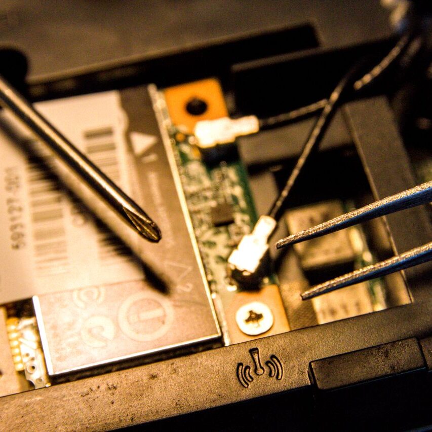 Detailed view of a laptop's internal parts being repaired with tools.
