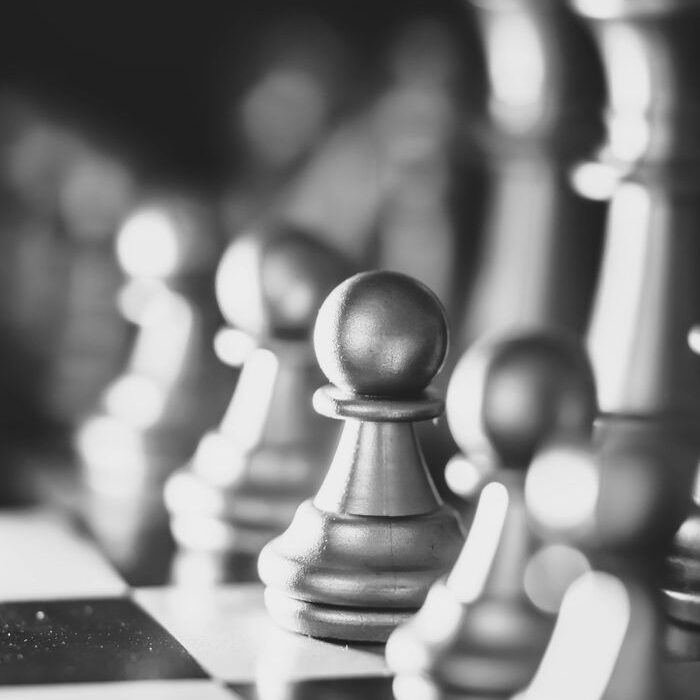 Close-up view of shiny chess pieces reflecting light on a board.
